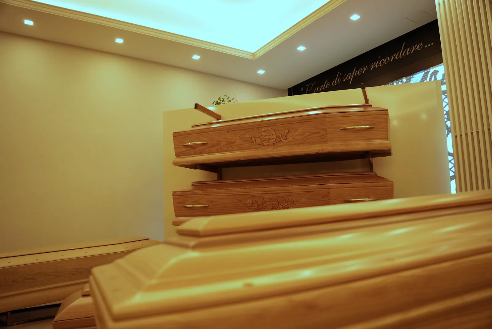 Cofani esposti sotto la luce calda del soffitto della sala mostra