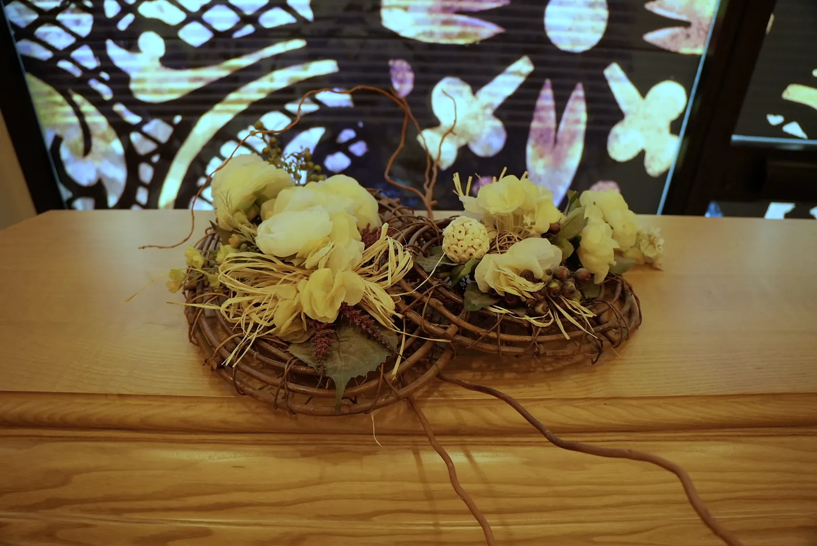 Composizione floreale di fiori secchi davanti a una vetrata artistica retroilluminata
