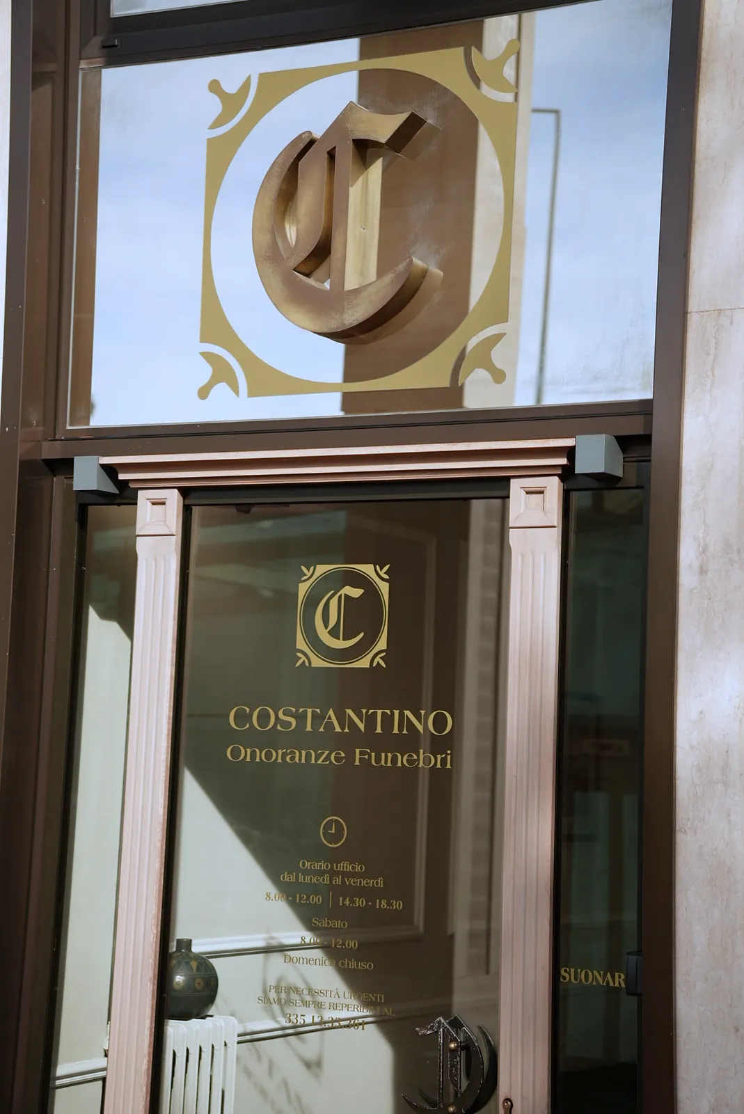 Il monogramma Costantino in ottone sulla vetrata dell'ingresso