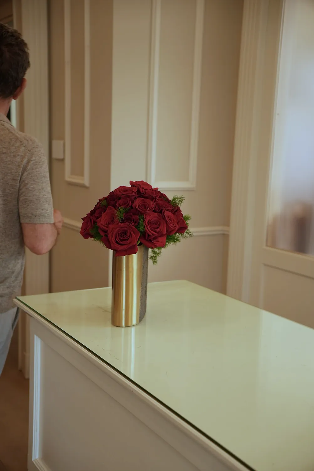 Rose rosse sistemate in un vaso d'ottone sul bancone dell'accoglienza